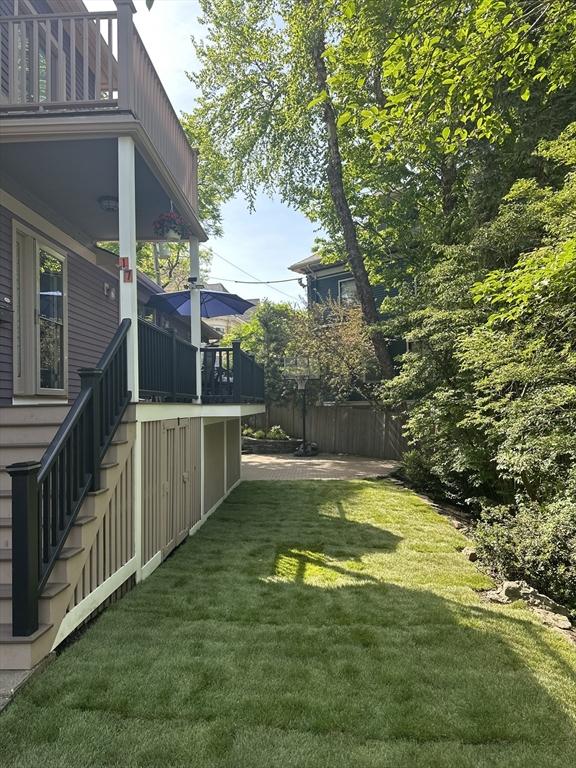 view of yard with stairway and a balcony