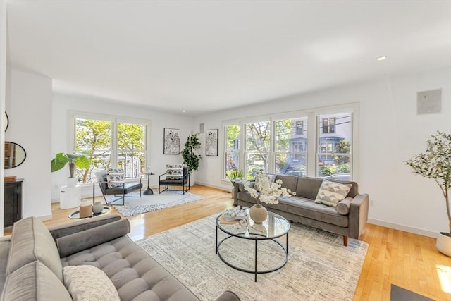 living area with light wood-style flooring, baseboards, and recessed lighting