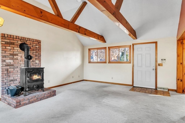 unfurnished living room with carpet floors, lofted ceiling with beams, and a wood stove