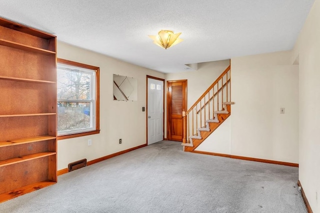 carpeted entrance foyer with a textured ceiling