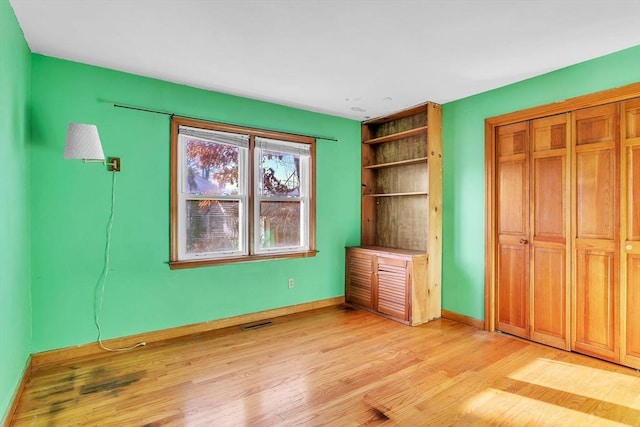 unfurnished bedroom featuring light hardwood / wood-style flooring and a closet