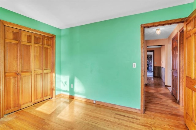 unfurnished bedroom featuring light hardwood / wood-style flooring and a closet