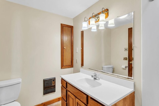 bathroom featuring vanity, toilet, and heating unit