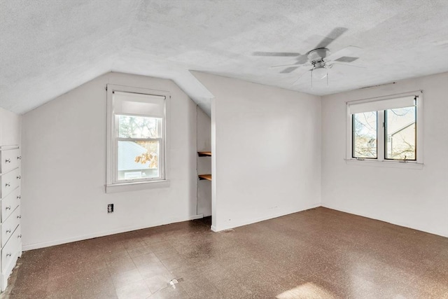 additional living space featuring a textured ceiling, vaulted ceiling, and ceiling fan