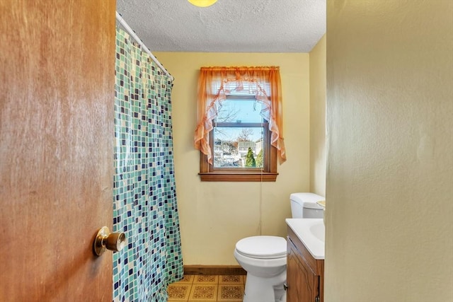 bathroom featuring walk in shower, vanity, a textured ceiling, and toilet