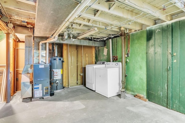 basement with heating unit, water heater, and washer and clothes dryer