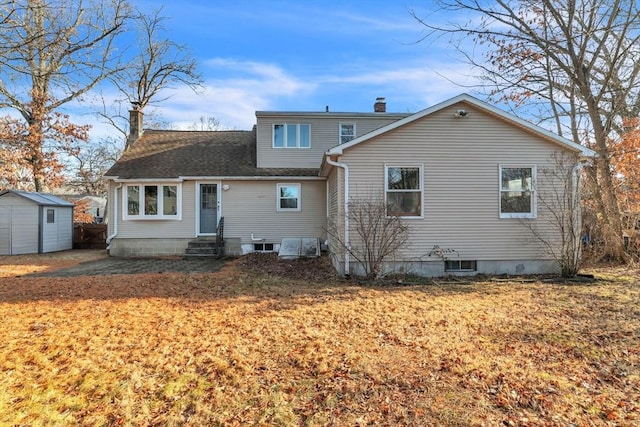 rear view of house featuring a lawn and a storage shed