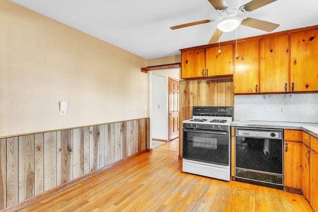 kitchen featuring gas range gas stove, ceiling fan, black dishwasher, backsplash, and light hardwood / wood-style floors