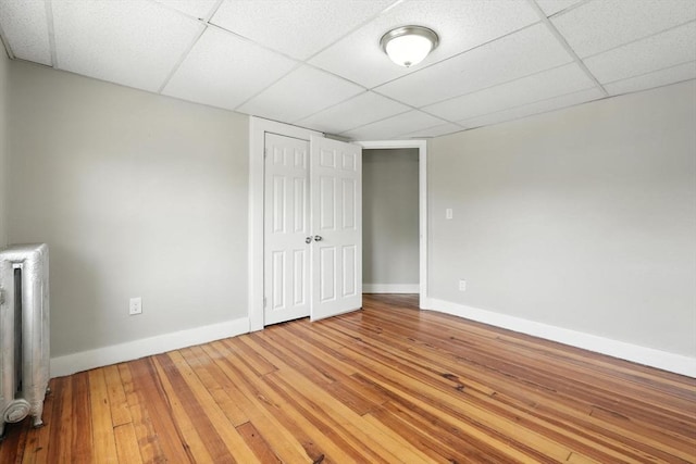 782 Sumner Ave, Springfield, MA 01108 - unfurnished bedroom with radiator heating unit, a paneled ceiling, hardwood / wood-style floors, and a closet