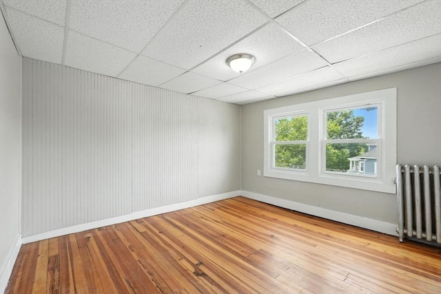782 Sumner Ave, Springfield, MA 01108 - empty room featuring radiator heating unit, hardwood / wood-style flooring, and a drop ceiling