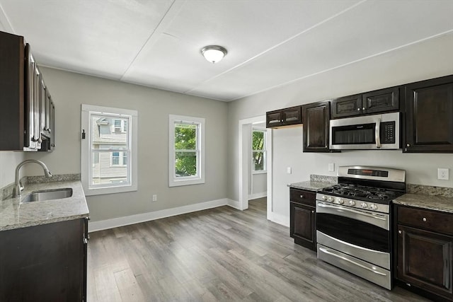 782 Sumner Ave, Springfield, MA 01108 - kitchen featuring appliances with stainless steel finishes, light wood-style floors, light stone counters, and dark brown cabinetry