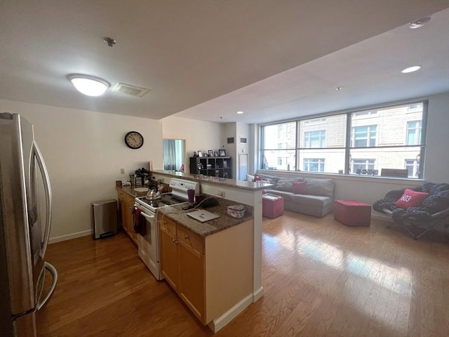 234 Causeway St Unit 723, Boston, MA 02114 - kitchen with freestanding refrigerator, white range with electric cooktop, a peninsula, and light wood-type flooring