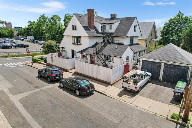 24 Central St, Somerville, MA 02143 - view of front of property featuring stucco siding, a chimney, and a detached garage