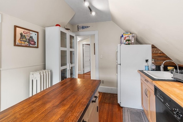 24 Central St, Somerville, MA 02143 - kitchen with butcher block counters, radiator, black dishwasher, freestanding refrigerator, and a sink