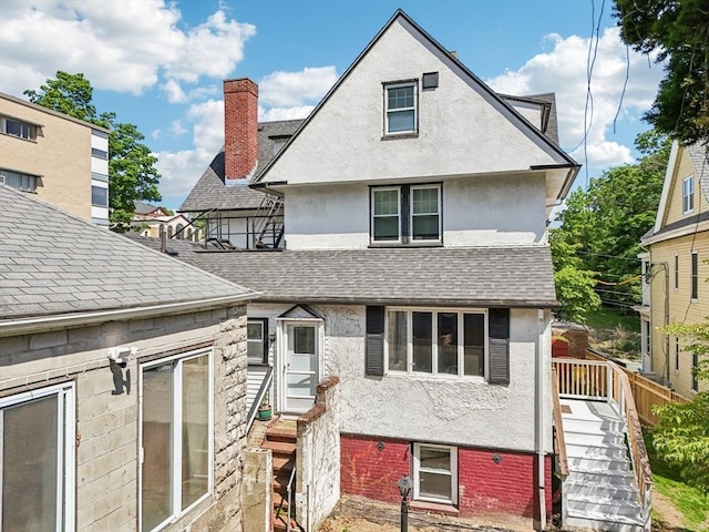 24 Central St, Somerville, MA 02143 - rear view of house with stucco siding, a shingled roof, entry steps, and stairs