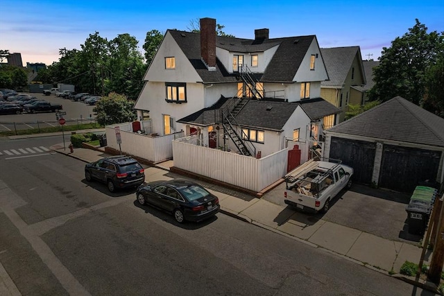 24 Central St, Somerville, MA 02143 - view of front of property with stucco siding, a chimney, and roof with shingles