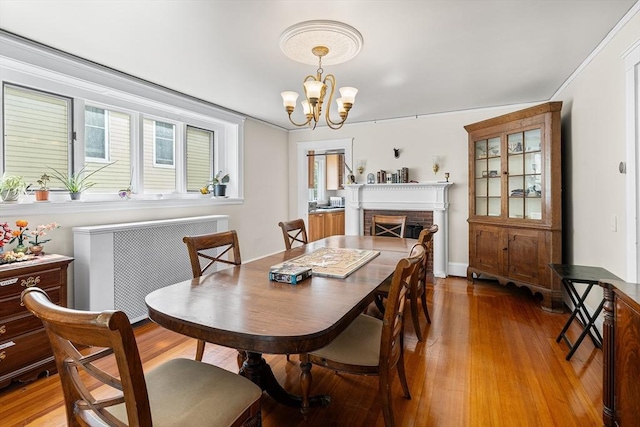 24 Central St, Somerville, MA 02143 - dining area with a chandelier, light wood-type flooring, and a brick fireplace