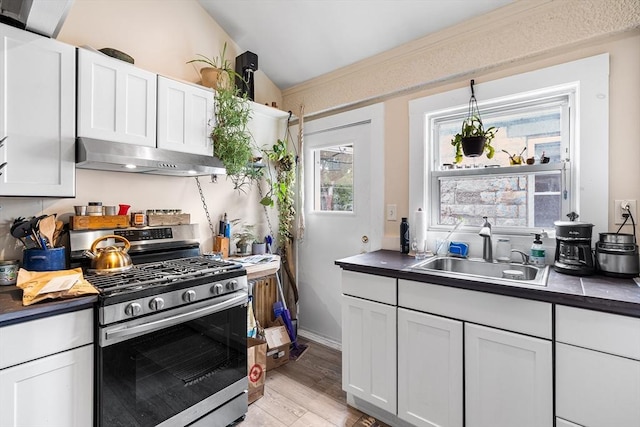 24 Central St, Somerville, MA 02143 - kitchen with stainless steel range with gas stovetop, a sink, ventilation hood, and dark countertops