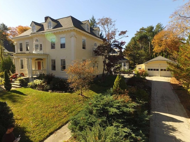 view of front of property featuring an outbuilding, a garage, and a front yard