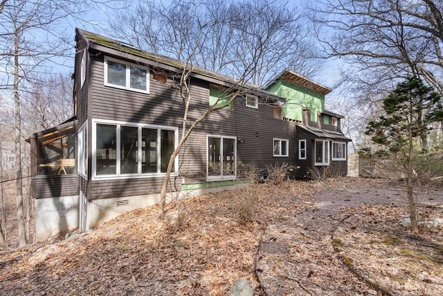 back of property featuring a sunroom and crawl space