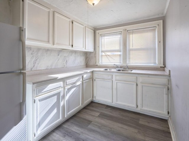 kitchen with sink, light hardwood / wood-style flooring, white cabinets, and white fridge