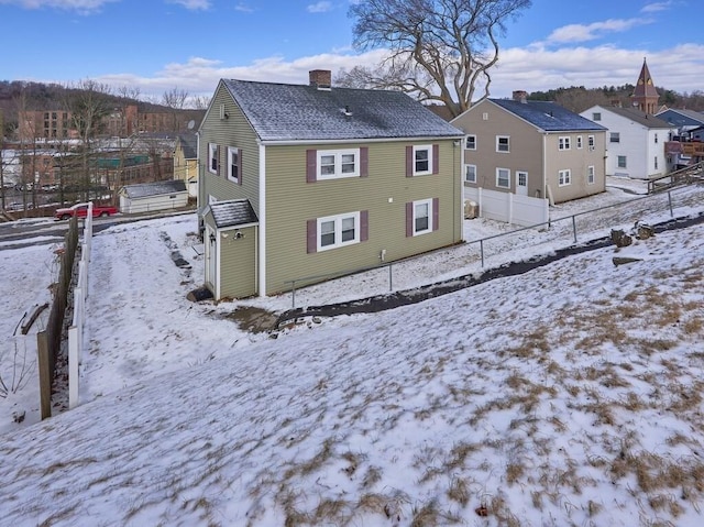 view of snow covered rear of property