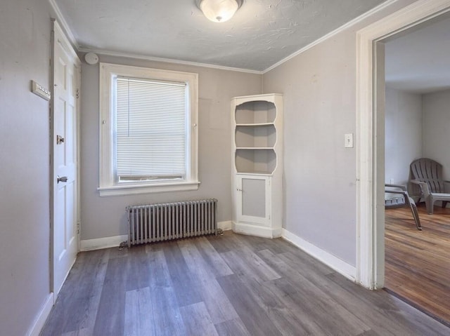 spare room with radiator, hardwood / wood-style flooring, and ornamental molding