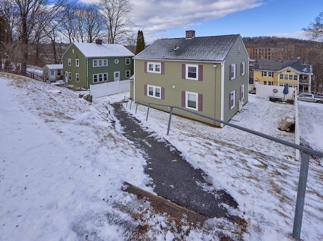 view of snow covered back of property