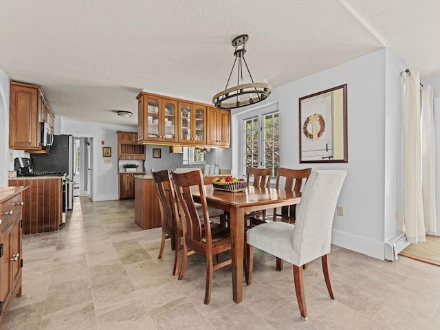 dining space with baseboards and a notable chandelier