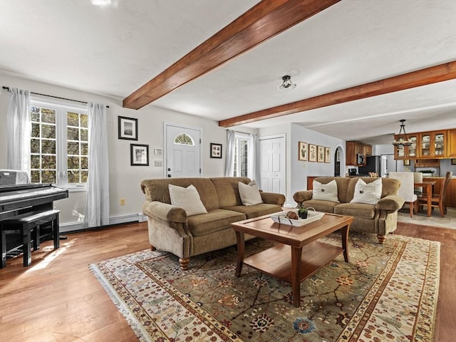 living room featuring light wood-type flooring, baseboards, beam ceiling, and a chandelier