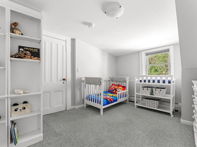 bedroom featuring baseboards, a crib, and carpet