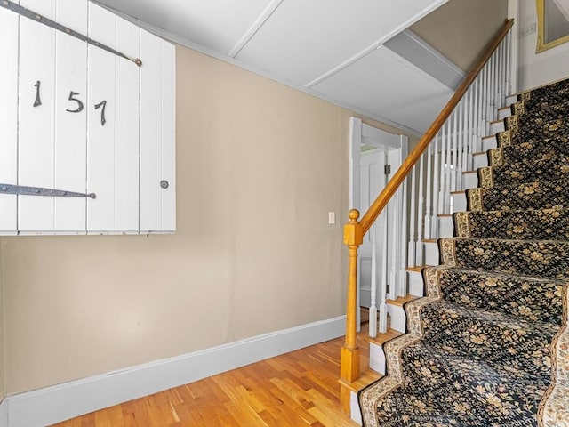 stairway with baseboards and wood finished floors
