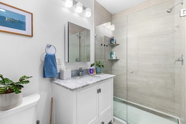 bathroom featuring vanity, toilet, and a shower with shower door