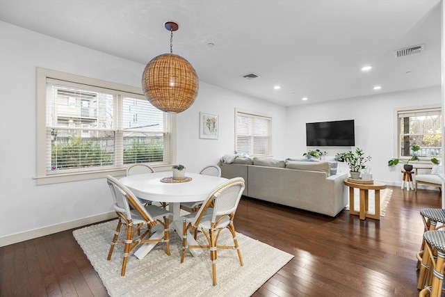 dining room with dark hardwood / wood-style flooring and a wealth of natural light