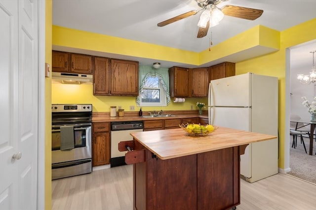 kitchen with light hardwood / wood-style floors, wooden counters, white appliances, ceiling fan with notable chandelier, and sink