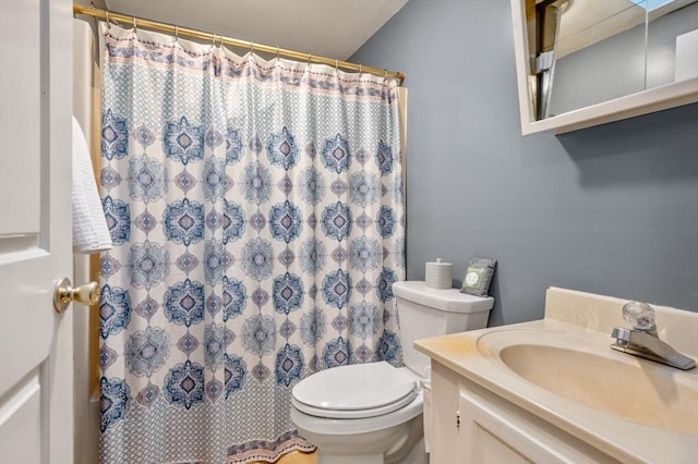 bathroom with toilet, vanity, and walk in shower