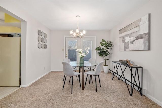 carpeted dining space featuring a chandelier