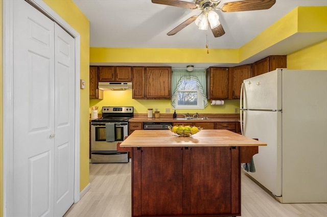 kitchen featuring butcher block counters, stainless steel electric range oven, a center island, white refrigerator, and sink