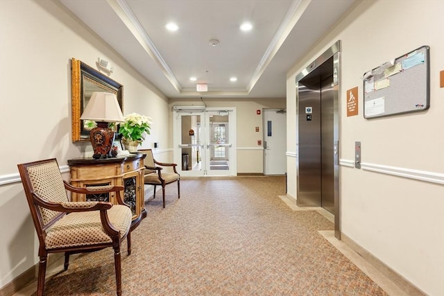 corridor featuring a tray ceiling, elevator, crown molding, and french doors