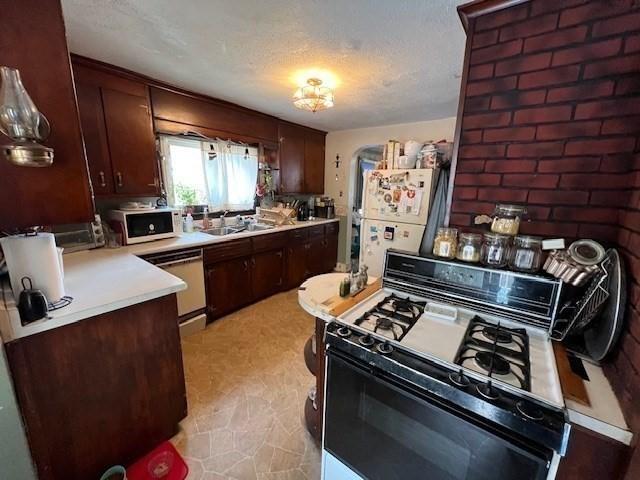 59 Eddy St, Springfield, MA 01104 - kitchen featuring white appliances, light countertops, dark brown cabinets, and a textured ceiling