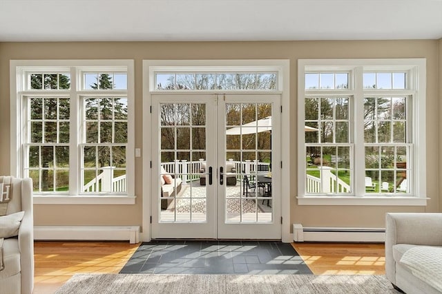 doorway featuring french doors, baseboard heating, a baseboard heating unit, and a wealth of natural light