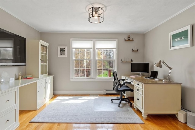 office area featuring crown molding, a baseboard heating unit, light wood-style flooring, and visible vents