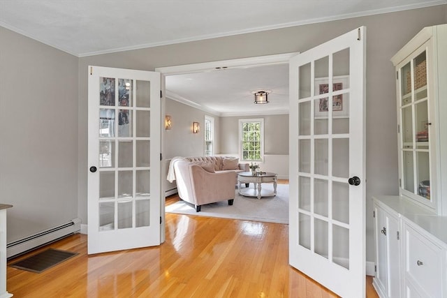 interior space featuring ornamental molding, french doors, light wood finished floors, and a baseboard radiator