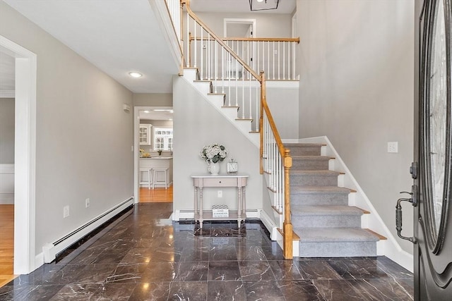 stairway featuring baseboards, a baseboard radiator, a baseboard heating unit, and marble finish floor