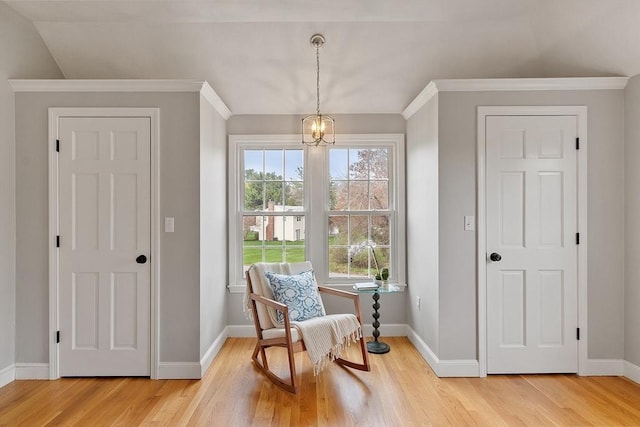 living area featuring baseboards, ornamental molding, and light wood-style floors