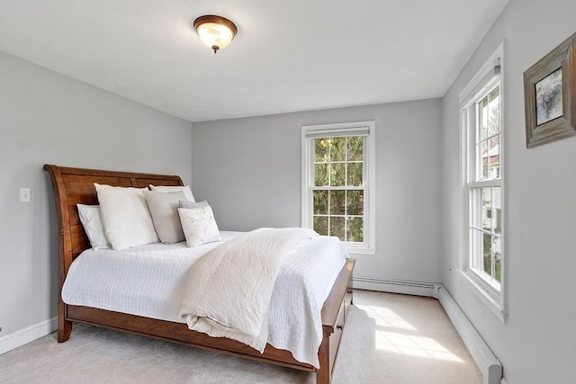 bedroom featuring a baseboard heating unit, baseboards, light colored carpet, and a baseboard radiator
