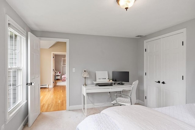 bedroom with visible vents, baseboards, baseboard heating, and a closet