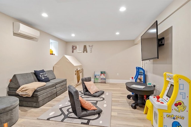 rec room featuring light wood-style floors, a wall mounted air conditioner, and recessed lighting