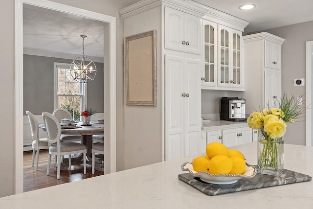 kitchen featuring an inviting chandelier, recessed lighting, white cabinetry, and glass insert cabinets