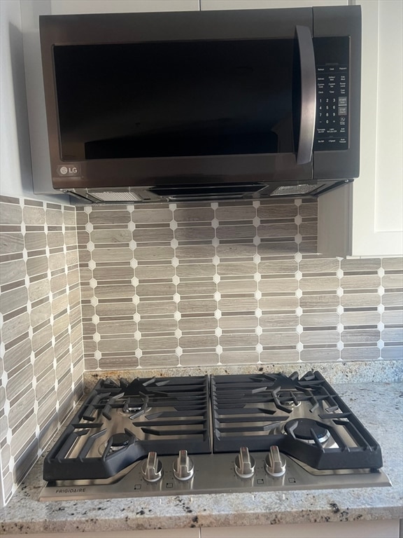 room details with appliances with stainless steel finishes and tasteful backsplash